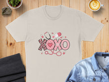 Load image into Gallery viewer, T-shirt with "XOXO" design featuring stethoscope, pills, and heart pattern.
