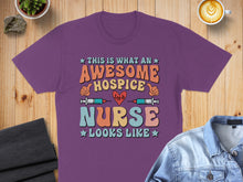 Load image into Gallery viewer, Purple t-shirt with "Awesome Hospice Nurse" text and medical icons.