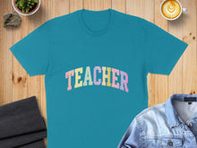 Load image into Gallery viewer, Teal t-shirt with "TEACHER" in pastel lettering, flat lay with coffee and jacket.