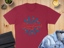 Load image into Gallery viewer, Burgundy t-shirt with "America" in retro font surrounded by starburst.