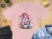 Load image into Gallery viewer, Pink t-shirt with a gnome nurse illustration holding a heart and stethoscope.