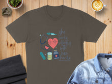 Load image into Gallery viewer, Brown t-shirt with stethoscope, syringe, bandages, and quote: "She works willingly with her hands."