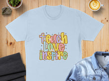 Load image into Gallery viewer, Light blue t-shirt with "Teach Love Inspire" in colorful, retro lettering.