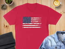 Load image into Gallery viewer, Red t-shirt with distressed American flag graphic and coffee and denim jacket props.