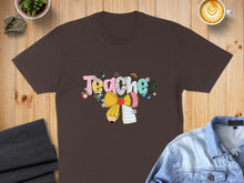Load image into Gallery viewer, Brown t-shirt with colorful "Teacher" text and pencil graphic.