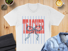 Load image into Gallery viewer, White t-shirt with "TEACHER" text and a blue bow design.