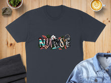Load image into Gallery viewer, Dark t-shirt with "NURSE" text graphic featuring stethoscope and floral elements.