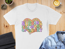Load image into Gallery viewer, White t-shirt with "Nursing is a work of heart" in colorful retro text and flowers.