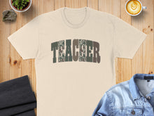 Load image into Gallery viewer, Cream t-shirt with "TEACHER" text in a camouflage pattern.