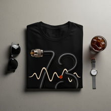 Load image into Gallery viewer, Black t-shirt with coiled black hose forming "73" and a waveform graphic.