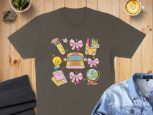 Load image into Gallery viewer, T-shirt with cartoon school bus, books, lightbulb, globe, and art supplies.
