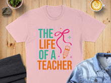 Load image into Gallery viewer, Pink t-shirt with "The Life of a Teacher" text and pencil illustration.