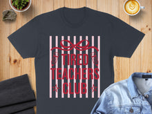 Load image into Gallery viewer, Dark t-shirt with "Tired Teachers Club" text and red bow.