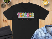 Load image into Gallery viewer, Black t-shirt with colorful "TEACHER" text and "teach love inspire" phrase.