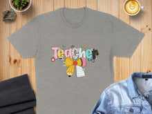 Load image into Gallery viewer, Grey t-shirt with "Teacher" in colorful patterned letters and school supplies.