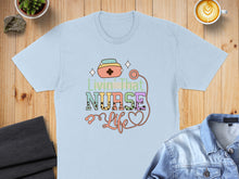 Load image into Gallery viewer, Light blue t-shirt with "Livin' That Nurse Life" text and stethoscope design.