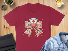Load image into Gallery viewer, Maroon t-shirt with a pink bow graphic featuring a stethoscope and heart.