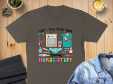 Load image into Gallery viewer, Gray t-shirt with "Can't talk right now doing nurse stuff" and medical icons.