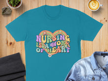 Load image into Gallery viewer, Teal t-shirt with colorful "Nursing is a work of heart" graphic.