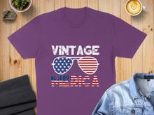 Load image into Gallery viewer, Purple t-shirt with "VINTAGE AMERICA" text and flag sunglasses graphic.