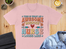 Load image into Gallery viewer, Pink t-shirt with "This is what an awesome hospice nurse looks like" text and medical icons.