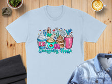 Load image into Gallery viewer, Illustration of a nurse with coffee and desserts on a light blue t-shirt.