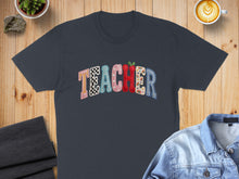 Load image into Gallery viewer, Dark t-shirt with colorful, block-letter "Teacher" graphic and coffee.
