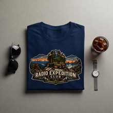 Load image into Gallery viewer, Navy t-shirt with "Radio Expedition Club" graphic depicting a mountain and coastal scene.