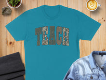 Load image into Gallery viewer, Teal t-shirt with "TEACH" in camouflage lettering.