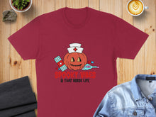 Load image into Gallery viewer, Maroon t-shirt with a Halloween pumpkin nurse design and text "Spooky Vibes & That Nurse Life."