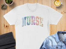Load image into Gallery viewer, White t-shirt with "NURSE" spelled out in colorful, patterned patchwork letters.