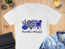 Load image into Gallery viewer, White t-shirt with blue leopard print peace sign, heart, and dental graphics, text reads "Peace love dental".
