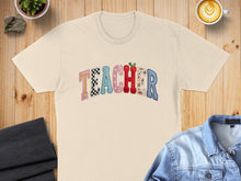 Load image into Gallery viewer, Cream t-shirt with "TEACHER" in colorful, patterned letters.