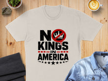 Load image into Gallery viewer, Cream t-shirt with "NO KINGS IN AMERICA" text and a red prohibition symbol.