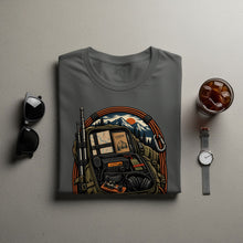 Load image into Gallery viewer, T-shirt graphic of a backpack with radio, logbook, and mountain sunset scene.