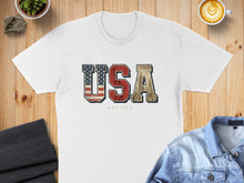 Load image into Gallery viewer, White t-shirt with "USA EST 1776" text featuring American flag and cityscape.