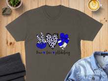 Load image into Gallery viewer, T-shirt with peace sign, heart, and syringe design and "Peace love phlebotomy" text.