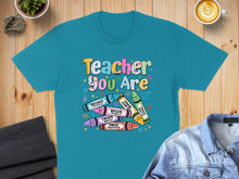 Load image into Gallery viewer, Teal t-shirt with "Teacher You Are" and scripture-labeled crayons.