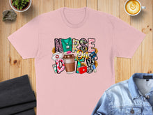 Load image into Gallery viewer, Pink t-shirt with "Nurse" graphic featuring medical and floral elements.