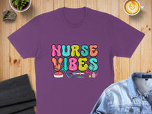 Load image into Gallery viewer, Purple t-shirt with "Nurse Vibes" in colorful retro lettering and medical icons.