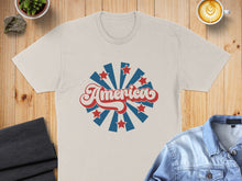 Load image into Gallery viewer, Beige t-shirt with red and blue "America" text surrounded by starburst.