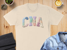Load image into Gallery viewer, Cream t-shirt with "CNA" spelled out in colorful patchwork letters.