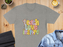 Load image into Gallery viewer, Grey t-shirt with "Teach Love Inspire" text in colorful, retro lettering.