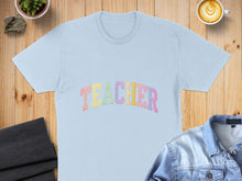 Load image into Gallery viewer, Light blue t-shirt with pastel "TEACHER" text arched across the chest.