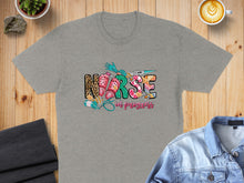 Load image into Gallery viewer, Grey t-shirt with "Nurse in progress" text and medical icons.