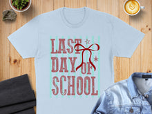 Load image into Gallery viewer, Light blue t-shirt with "Last Day of School" text and a red ribbon graphic.