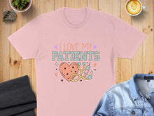 Load image into Gallery viewer, Pink t-shirt with "I Love My Patients" text, heart, and stethoscope graphic.
