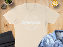 Load image into Gallery viewer, Cream t-shirt with "America, Land of the Free, Since 1776, Because of the Brave" text.