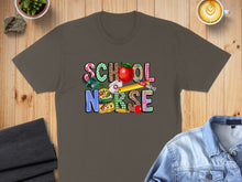 Load image into Gallery viewer, School Nurse text with apple, backpack, and other school supplies on brown t-shirt.