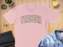 Load image into Gallery viewer, Pink t-shirt with "TEACHER" printed in floral letters.